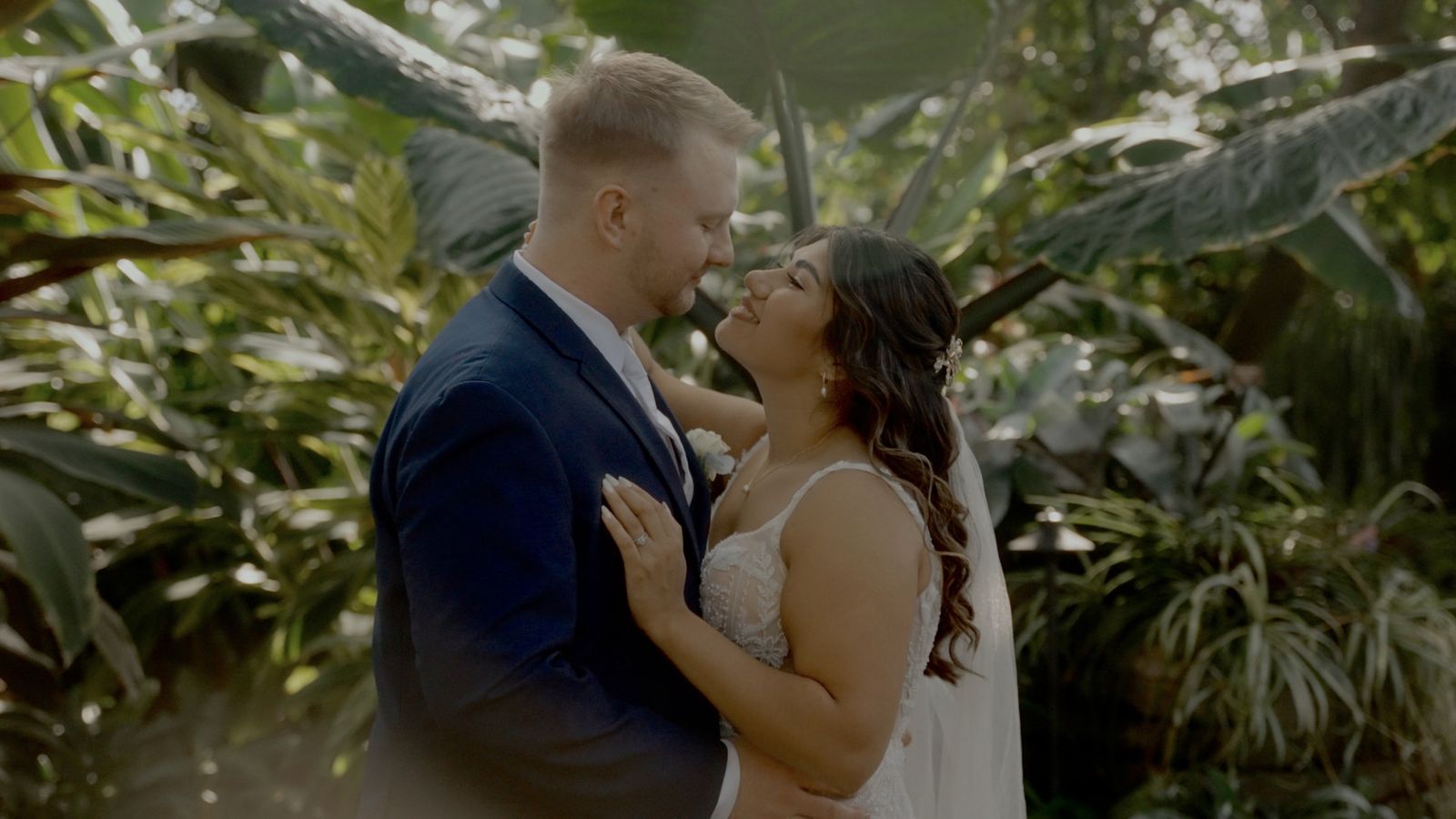 Couple embracing among tropical leaves